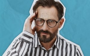 homem de oculos com mão na cabeça