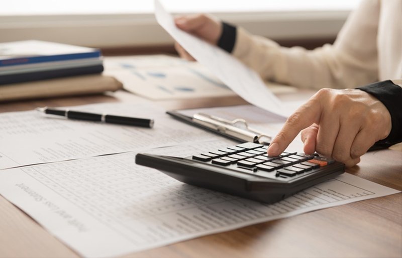 controle orçamentário - mão na calculadora e fazendo contas