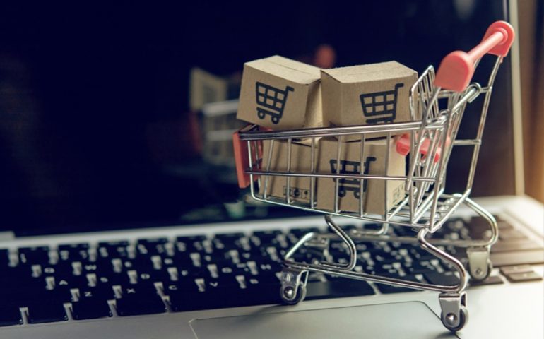 aumentar as vendas: computador com carrinho de compras e caixas